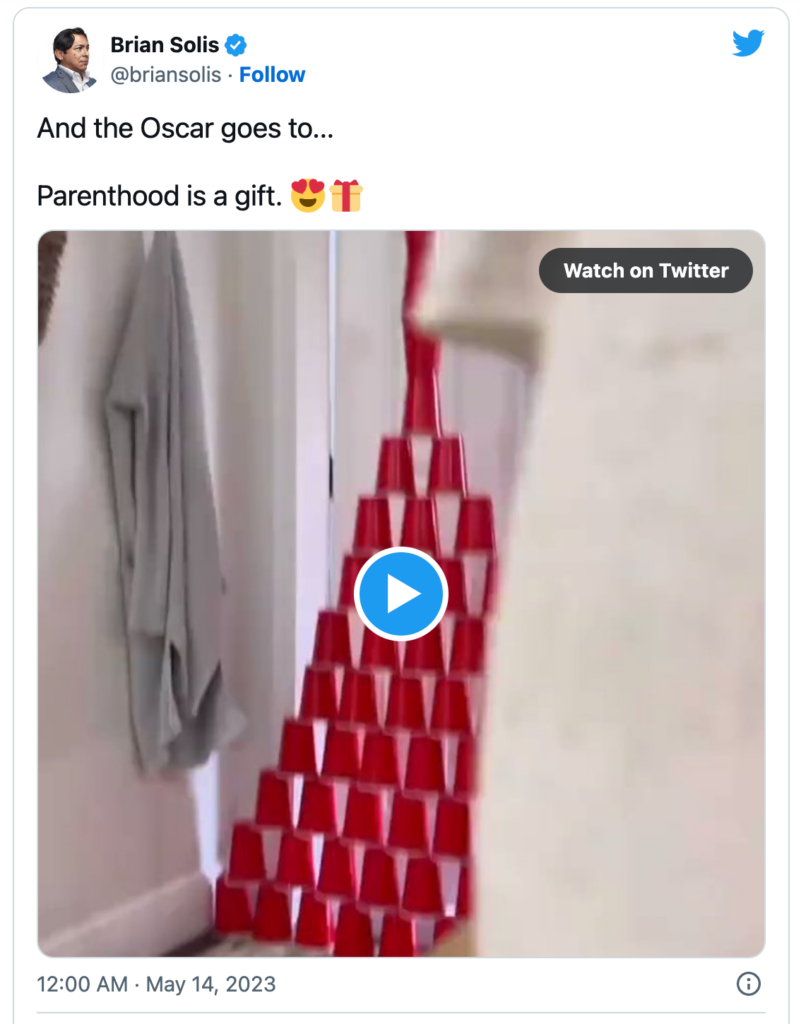 Screencapture of a tweet by BrianSolis of a doorway blocked by a pyramid of stacked red solo cups. Caption in the tweet: “And the Oscar goes to… Parenthood is a gift 😍 🎁”